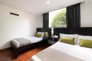 波哥大Hotel Dorado 100的一间卧室设有两张床和窗户。