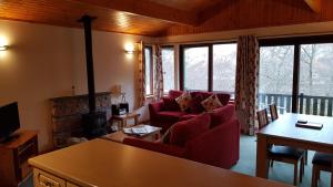 巴拉胡利什Birch Chalet的客厅设有红色的沙发和壁炉