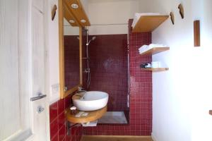 CoriCincinnato Wine Resort的浴室设有水槽和红色瓷砖淋浴。