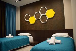 KakavijëBluePoint Hotel的黄色和蓝色的客房内的两张床