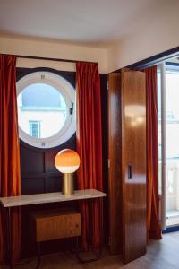 巴黎Hôtel Le Ballu的客房设有窗户和带台灯的桌子