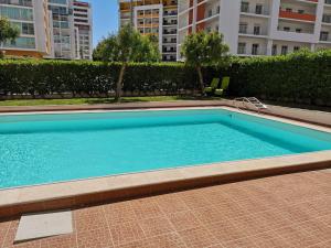 波尔蒂芒Espirito Santo Apartment的大楼内的一个蓝色海水游泳池