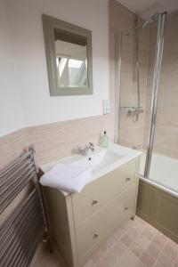 奇平卡姆登Hook Cottage的浴室配有盥洗盆和带镜子的淋浴