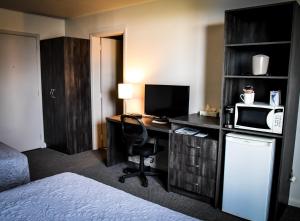Amos依柯诺万酒店的酒店客房配有书桌、电脑和微波炉