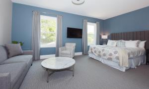 滨湖尼亚加拉皇后区124号Spa度假酒店的卧室拥有蓝色的墙壁,配有一张床和一张沙发