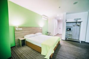 文尼察Optima Vinnytsia的一间卧室设有一张床和绿色的墙壁
