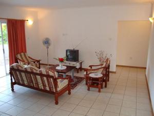 博瓦隆罗斯维拉宾馆的客厅配有椅子、桌子和电视