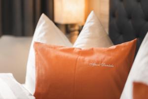 费斯丹妮拉公寓的床上的橙色枕头和白色枕头
