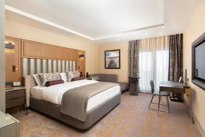 伯萨Almira Hotel Thermal Spa & Convention Center的酒店客房设有一张大床和一张书桌。