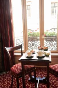 巴黎朗格鲁瓦酒店的桌子和两把椅子、桌子和窗户