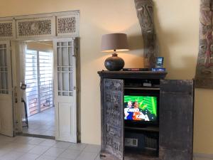 Oyster PondVilla CECILIA的客厅配有电视和带台灯的桌子