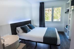 罗列特海岸里巴斯旅馆 的一间卧室配有床、水槽和窗户