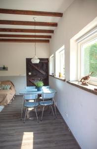 AchthuizenLavender Lodge的一间设有桌椅的房间,一只狗坐在窗户里