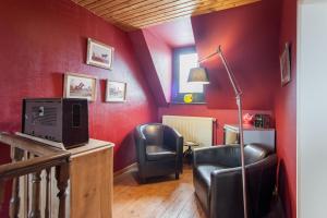 Nil Saint-Vincent瑟斯德拉图尔住宿加早餐旅馆的客厅设有红色墙壁和黑色椅子