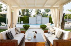 达西亚S & O Villas Corfu的带沙发和桌子的庭院以及游泳池。