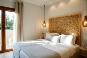 达西亚S & O Villas Corfu的卧室设有一张白色大床和一扇窗户。