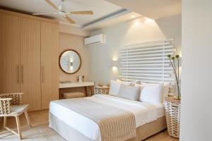 达西亚S & O Villas Corfu的一间卧室配有一张床、一张桌子和一面镜子