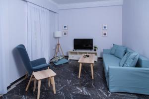 爱琴娜岛Afaia houses的客厅配有蓝色的沙发和两把椅子