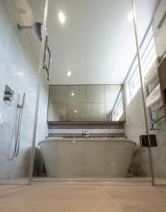 泰晤士河畔金斯顿金斯阿姆酒店的浴室配有浴缸及镜子