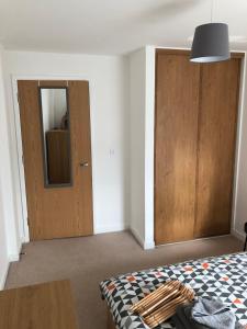 卡迪夫Quayside Apartment in Cardiff Bay的一间卧室配有一张床和一扇木门