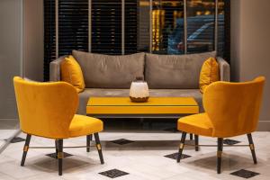 伊西翁万神殿城市酒店的客厅配有黄色椅子和沙发