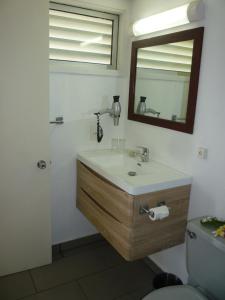 帕皮提皇家塔赫缇恩酒店的一间带水槽、镜子和卫生间的浴室