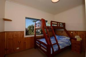 蚬壳港Seahaven Beach House - Shellharbour的一间卧室设有两张双层床和一扇窗户。