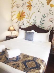 科隆Blue Waters Inn Coron Palawan的一间卧室配有一张带花卉壁纸的床