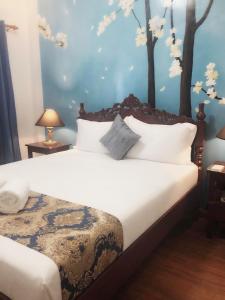 科隆Blue Waters Inn Coron Palawan的卧室配有白色的床铺,墙上有树木