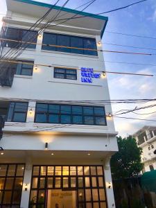 科隆Blue Waters Inn Coron Palawan的白色的建筑,上面有标志