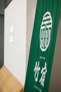 大阪Hostel Takeyado的一张桌子旁的绿色和白色标志