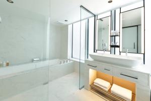 东京Hamacho Hotel Tokyo的一间带水槽、浴缸和镜子的浴室