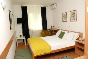 斯科普里7号酒店的一间卧室配有一张黄色毯子床