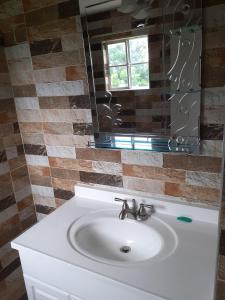 White HillGriffiths Home的浴室设有白色水槽和镜子