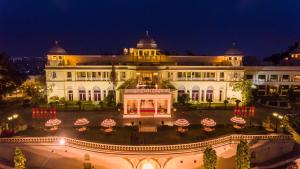乌代浦拉利特·拉克西米维拉斯宫酒店的一座白色的大建筑,晚上有庭院