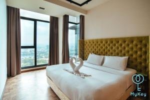 吉隆坡星汇吉隆坡型格麦基全球公寓式酒店的两个天鹅坐在酒店房间的床边