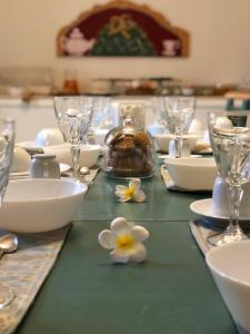 巴勒莫Casa Jolanda B&B的桌子上放有盘子和玻璃杯,花朵
