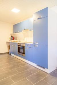 瓦尔德-米谢尔巴赫Casa Susanna的一间设有蓝色橱柜和瓷砖地板的大厨房