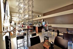 BiennoHotel Oasi Verde的餐厅设有酒吧,配有桌椅