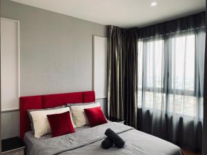 莎阿南Stellar Homes at iCity - with WiFi and 2 Private Carparks的一间卧室设有红色床头板和大窗户