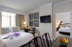 曼谷The Sukosol Hotel的酒店客房,配有一张床铺和一张桌子,还有一间客房