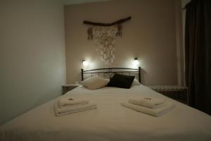 帕罗奇亚索非亚膳食公寓的卧室配有白色床和毛巾