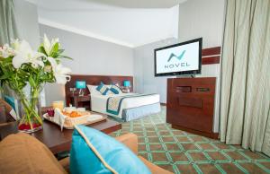 阿布扎比诺韦尔城市中心酒店的酒店客房,配有床和电视