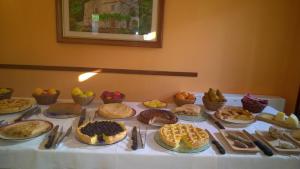卡拉马尼科泰尔梅洛坎达巴罗酒店的一张桌子,上面放着许多不同类型的蛋糕和馅饼