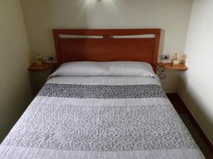 莫卡诺尔Casa Rural Los Perales的卧室内的一张带木制床头板的床