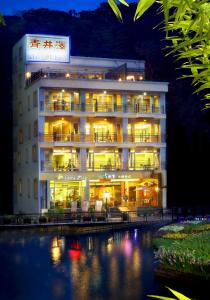 鱼池乡青井泽休闲旅店的夜间水灯照亮的酒店大楼