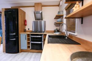 福丁布里奇桑迪巴尔斯度假村的厨房配有黑色冰箱和水槽