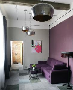 利加特内Zeit Hotel的客厅配有紫色沙发和桌子