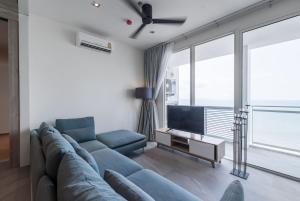 乔木提恩海滩3BR Seaview/HighFloor/Veranda Residence Pattaya的客厅配有蓝色的沙发和电视
