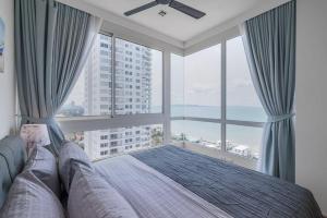 乔木提恩海滩3BR Seaview/HighFloor/Veranda Residence Pattaya的一间卧室设有一张床和一个大窗户